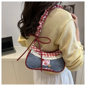 Detail of denim underarm bag with red gingham trim and a cute cherry patch