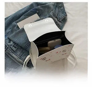 Vue intérieure du sac blanc à motif de chien montrant le téléphone et le portefeuille