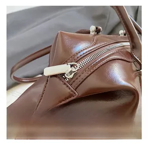 Close-up of the vintage brown leather bag showing premium metal zipper and fine stitching