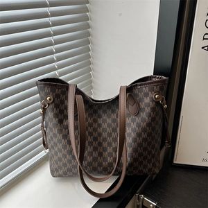 Classic large brown tote bag with M-letter pattern and dual handles in soft sunlight