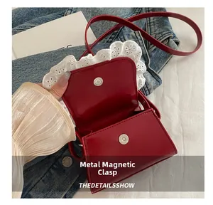 Detail shot of the secure magnetic buckle on the red lace-trimmed square crossbody bag