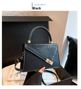 Détail du sac à bandoulière noir avec rabat texture crocodile et fermoir doré rotatif