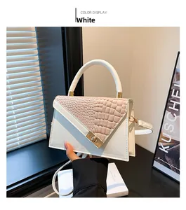 Détail du sac à main blanc avec rabat rose motif croco et fermoir rotatif doré