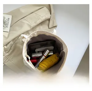 Top view of spacious beige tote bag interior showing capacity for tablet, umbrella, and cosmetics