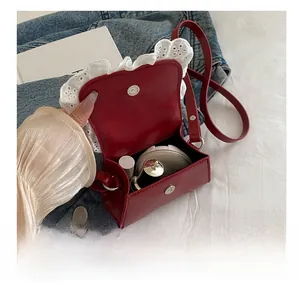 Interior view showing the capacity of a wine red leather bow bag with lace details