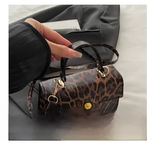 Detail of leopard print handbag with gold twist lock and fine stitching texture