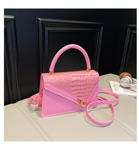 Détail d'un sac à main rose texture pierre avec fermoir doré et accessoires de mode