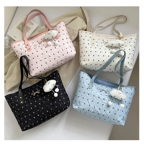 Flat lay of quilted tote bags in four colors with cat patterns and bow metal buckles