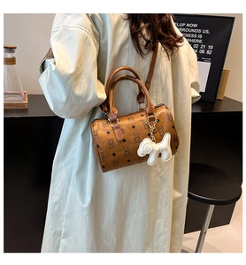 Sac polochon marron avec motif d'ours et pendentif chien porté par un mannequin