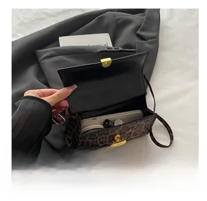 Detailed interior view of leopard print crossbody bag showing phone and lipstick storage