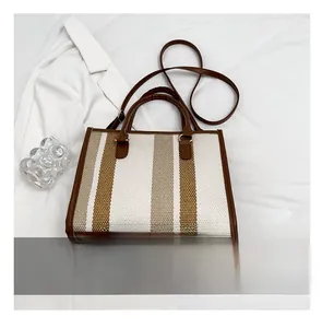 Detailed size comparison of the striped canvas tote bag next to a smartphone