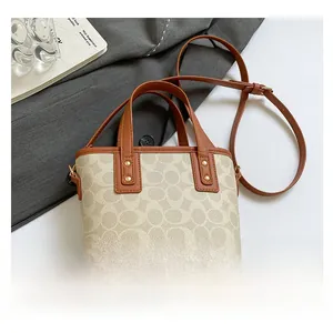 Detail der Jacquard-Beuteltasche mit Monogramm-Muster und braunem Ledergriff