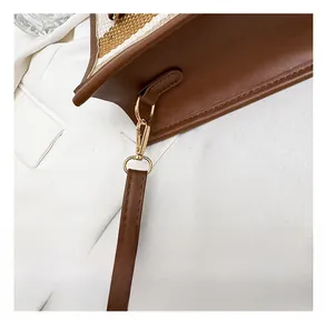 Detail of adjustable bronze hardware and shoulder strap on a brown tote bag
