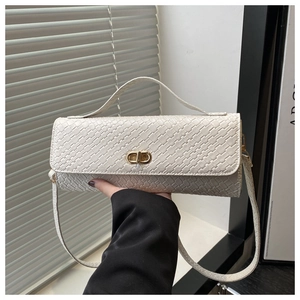 Detail of woven cream crossbody bag showing intricate texture and gold infinity metal lock