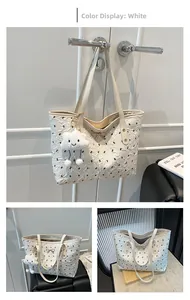 Detail of white tote bag with black bow prints, golden buckle and cloud plush charm