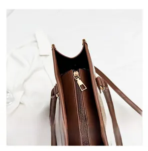 Detail shot of smooth gold-tone zipper and premium brown leather finish on handbag