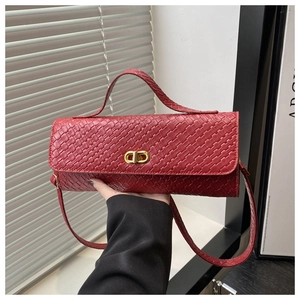 Detailed close-up of a red woven leather handbag featuring a golden swivel lock and top handle