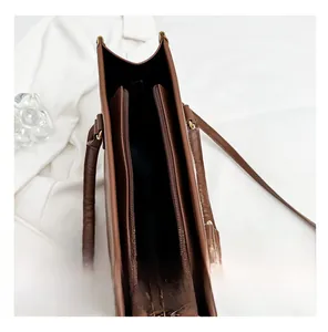 Detailed top view of the brown leather tote bag interior with zipper compartments