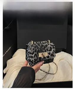 Detail of blue leopard print quilted mini bag with gold chain and metal twist lock