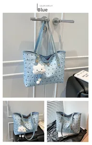 Close-up of blue quilted tote bag with rabbit patterns and golden bow detail