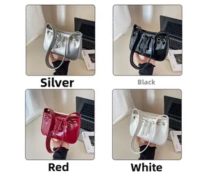 Detail view of glossy rectangular handbags in silver, black, red, and white leather finishes