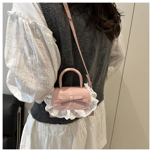 Close-up of pink mini crossbody bag featuring white lace trim and bow knot detail