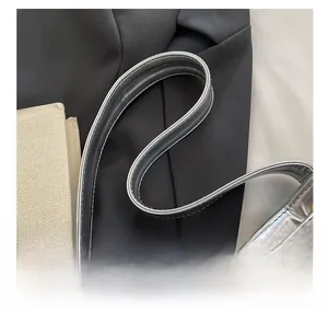 Detailed silver leather handle with S-curve design and gold metal eyelets on a bucket bag