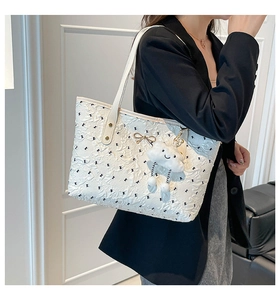 Detail of white pleated tote bag with golden bow and cute cloud plush charm detail
