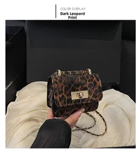 Detail of deep leopard print quilted bag featuring a golden metal twist lock and chain strap