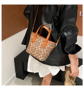 Detail einer Bucket Bag mit Vintage-Muster, verstellbarem Riemen und goldener Hardware