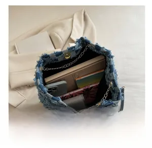Vue intérieure du sac en jean montrant sa grande capacité et ses détails de franges