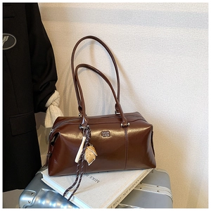 Detail of vintage brown bowling bag on a silver suitcase with a unique glove charm