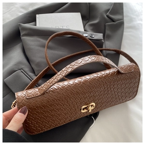 Detail shot of brown woven texture bag with gold metal buckle and shoulder strap