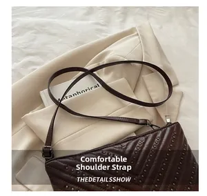 Close-up of dark brown quilted leather shoulder bag with silver studs and comfortable strap