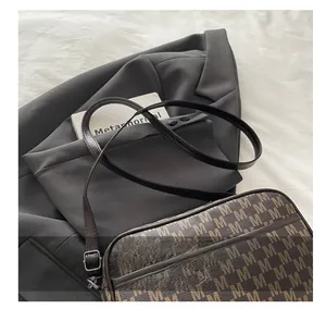 Detail of adjustable leather strap and vintage monogram pattern on crossbody camera bag
