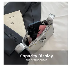Capacity display of silver metallic underarm bag showing sunglasses and cosmetics