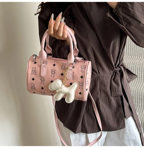 Détail du sac cylindrique rose avec motifs d'ours et accessoire de petit chien décoratif