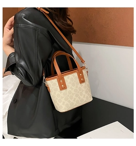 Detail der Vintage-Beuteltasche mit Monogramm-Muster, getragen von einem Model in Lederjacke