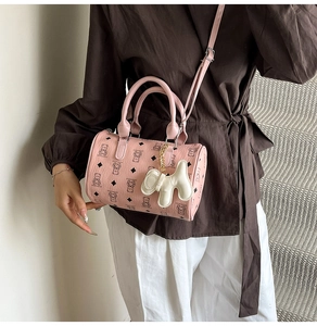 Détail du sac Boston rose avec motifs d'ours et charmant pendentif chiot blanc