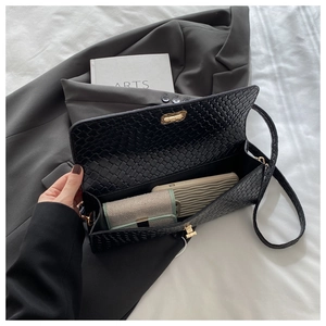Detail view of woven black clutch interior showing spacious storage for mobile and cards