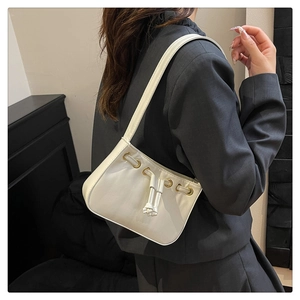 Detail of white leather shoulder bag with drawstring knot and gold metal eyelets