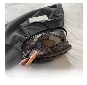 Top-down detail shot showing high capacity of brown monogram leather handbag with cosmetics