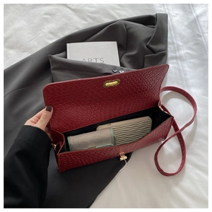 Macro detail of dark red woven bag interior and metallic gold twist lock closure