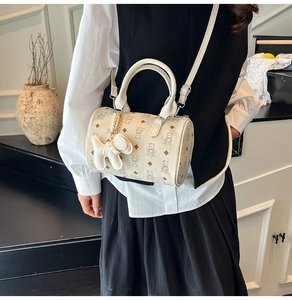 Détail du sac cylindrique beige avec imprimés d'ours et charmant pendentif chien
