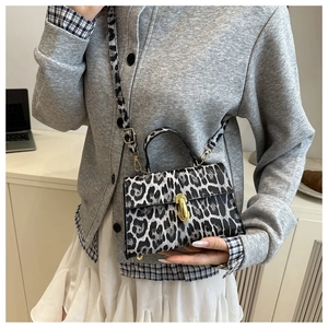 Detail of leopard print crossbody bag with gold metal twist lock and sturdy handle