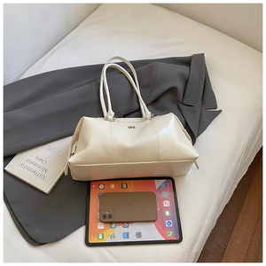 Spacious cream patent leather bowling bag showing storage capacity with an iPad