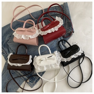 Flat lay of five mini crossbody bags in various colors with lace trim and bow accents