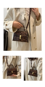 Detail of leopard print small square bag with golden C-shaped metal buckle and PU leather texture