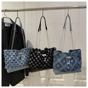 Détail de sacs en jean avec bords effilochés, chaînes en métal et pendentifs de cerf