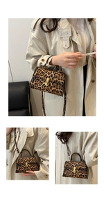 Detailed view of leopard print baguette bag featuring gold twist-lock and beige trench coat